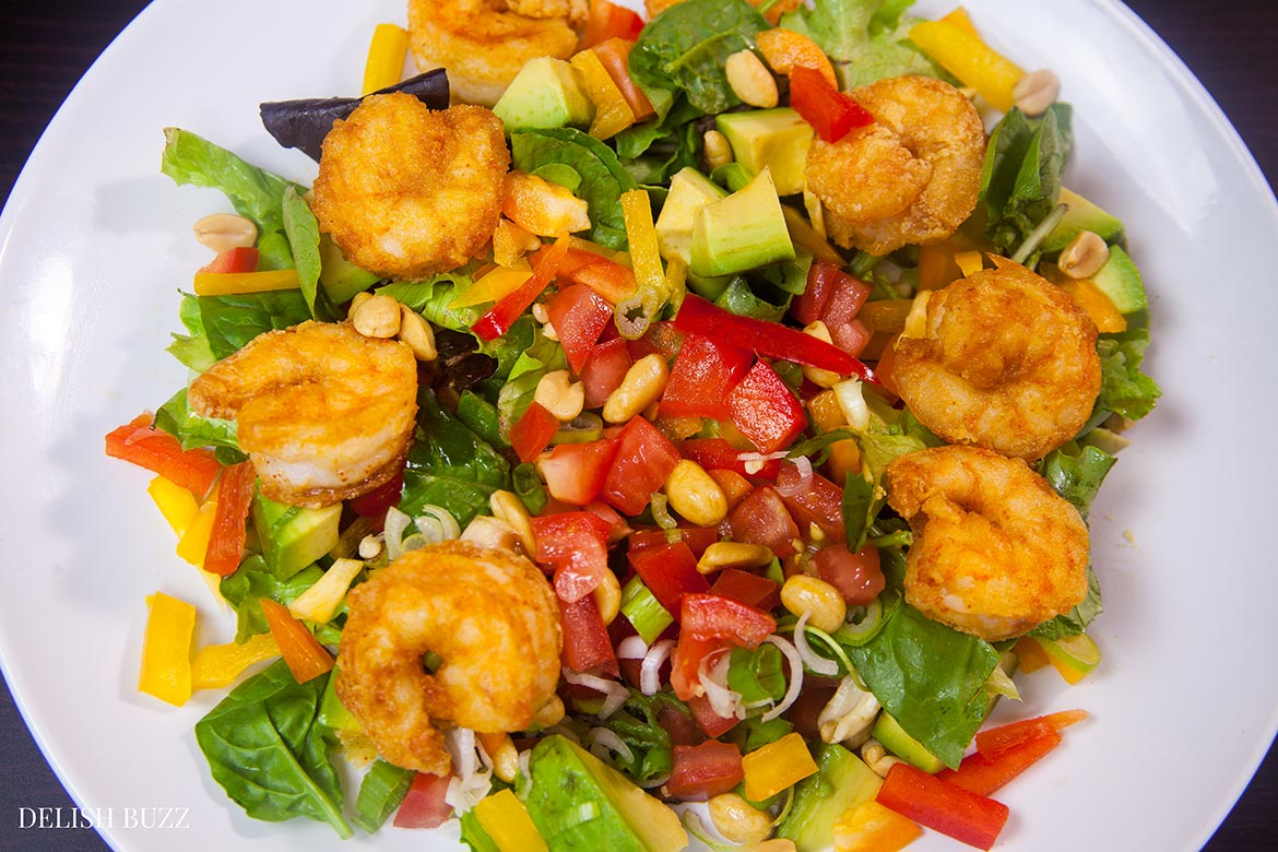 Shrimp avocado salad, a wonderfully satisfying main course salad. Crunchy, sweet, sour and nutty. This colorful salad explodes with flavors and textures. At the same time, it brings together luscious greens, sweet peppers, scallions, peanuts and creamy avocados with a perfectly crafted dressing. www.delishbuzz.com