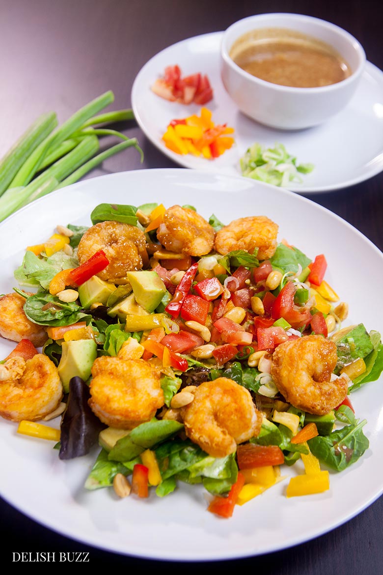 Shrimp avocado salad, a wonderfully satisfying main course salad. Crunchy, sweet, sour and nutty. This colorful salad explodes with flavors and textures. At the same time, it brings together luscious greens, sweet peppers, scallions, peanuts and creamy avocados with a perfectly crafted dressing. www.delishbuzz.com