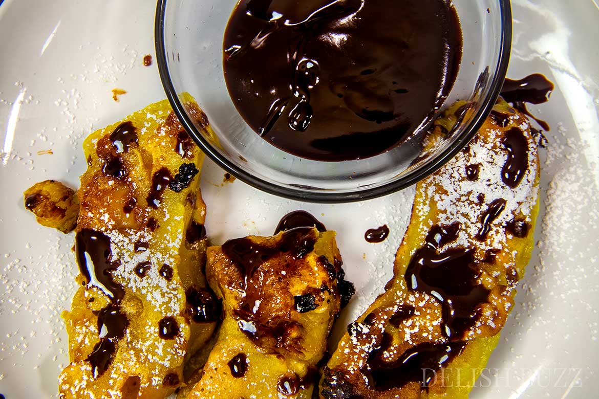 Easy to make vegan banana fritters are delicious. They have crispy golden outsides with delicious banana and melted caramel inside! Sparkling melted dark chocolate sauce adds extra yumminess. This luscious banana recipe is ready in minutes. www.delishbuzz.com