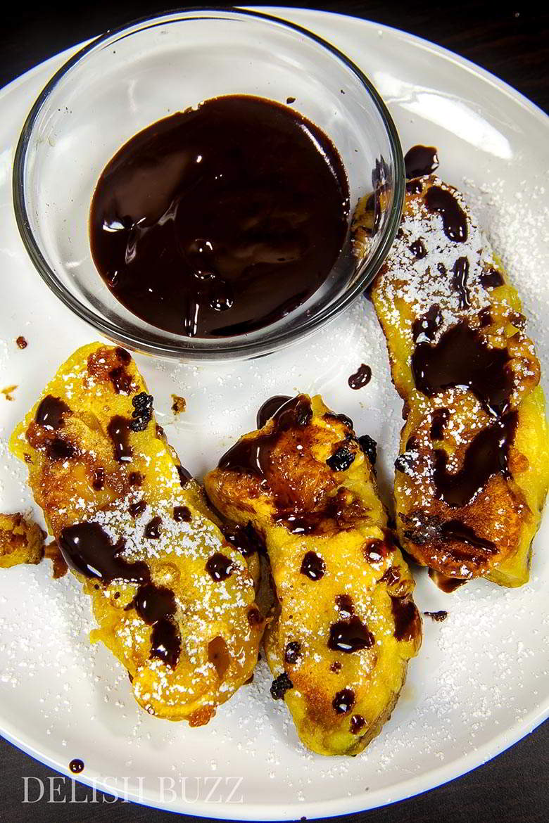 Vegan banana fritters are easy to whip up and are delicious. They have crispy golden outsides with delicious banana and melted caramel inside! Sparkling melted dark chocolate sauce adds extra yumminess. www.delishbuzz.com