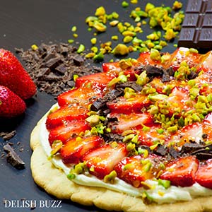 The finished product after your prep is one heck of a colorful dessert. Easy delicious summery gluten free strawberry pizza. Very refreshing and full of subtle flavors. Strawberries on a sugar cookie crust with a layer of light lemon scented creamy frosting with apricot glaze. This will be a show stopper on any dining table. www.delishbuzz.com