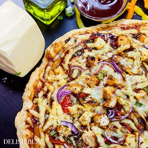 Smoked Gouda and smoked paprika do wonders here! Easy Barbecue Chicken Pizza explodes with flavors in your mouth. Instant no rise homemade crust along with barbecue sauce, sweet peppers and gouda cheese makes this pizza irresistible. www.delishbuzz.com