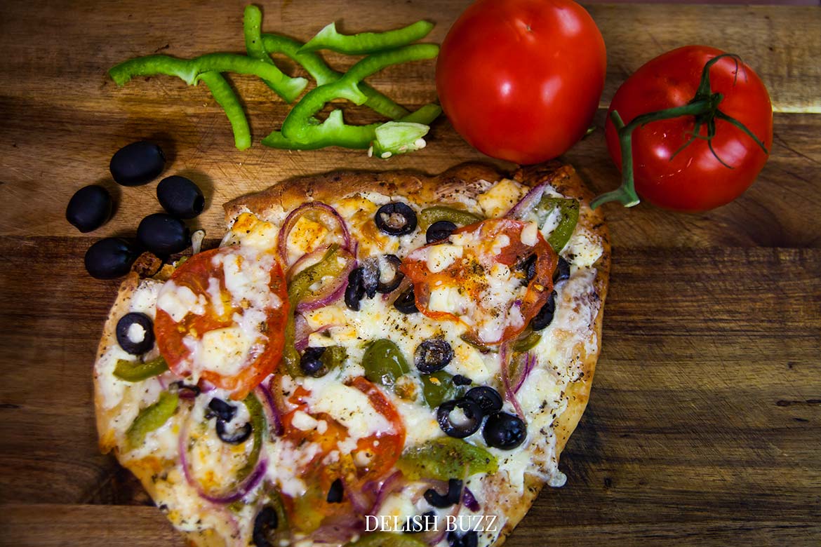 When this flatbread naan bread pizza is done, it is an irresistable sight! I love the aroma of melted cheese combined with pepers and olives. A robust Greek pizza, full of fresh crispy flavors. Satisfying naan bread pizza with perfectly melted cheeses. Perfect meal for a busy day. Prepped and ready to eat in minutes. - www.delishbuzz.com