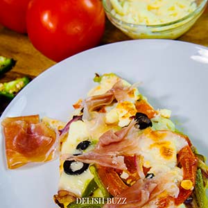 Prosciutto adds an extra layer of flavor to this recipe. A robust Greek pizza, full of fresh crispy flavors. Satisfying naan bread pizza with perfectly melted cheeses. Perfect meal for a busy day. Prepped and ready to eat in minutes. - www.delishbuzz.com