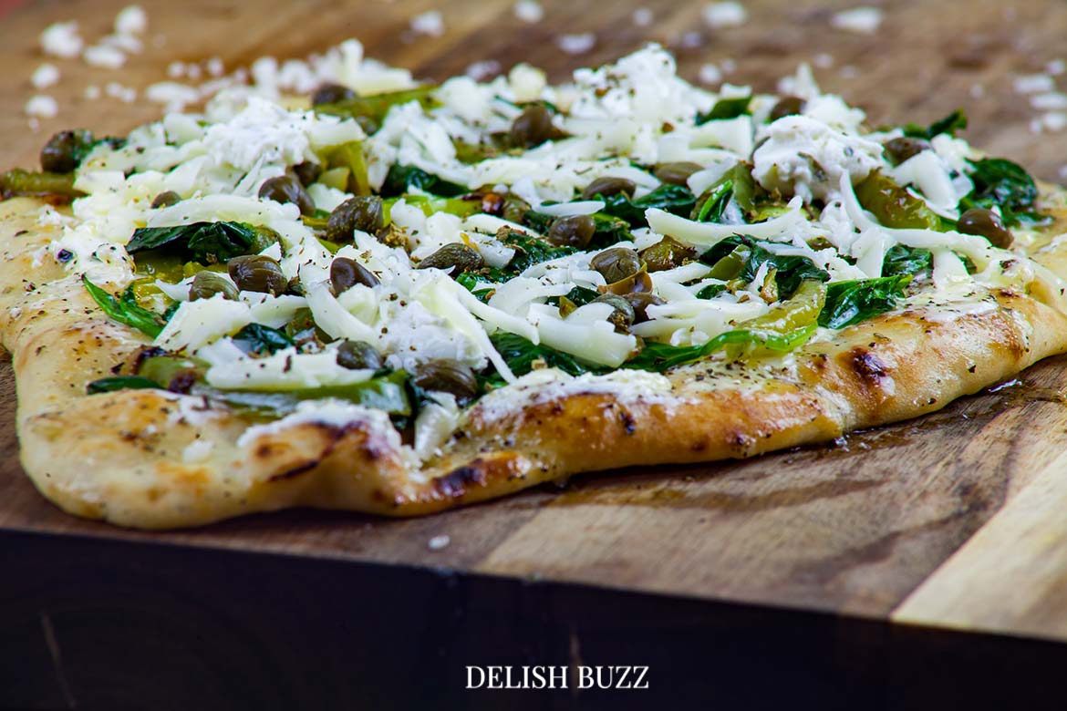 The smell of basil butter and crushed oregano fill the air. Basil butter naan white pizza is as good as artisan pizzas. This recipe will make you realize how easy it is whip up a delicious flatbread pizza at home. - www.delishbuzz.com